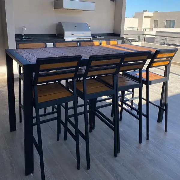 Mesa Akumal con sillas altas en una terraza