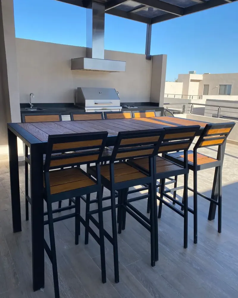 Mesa alta y sillas altas Mishka Garden en una terraza con asador